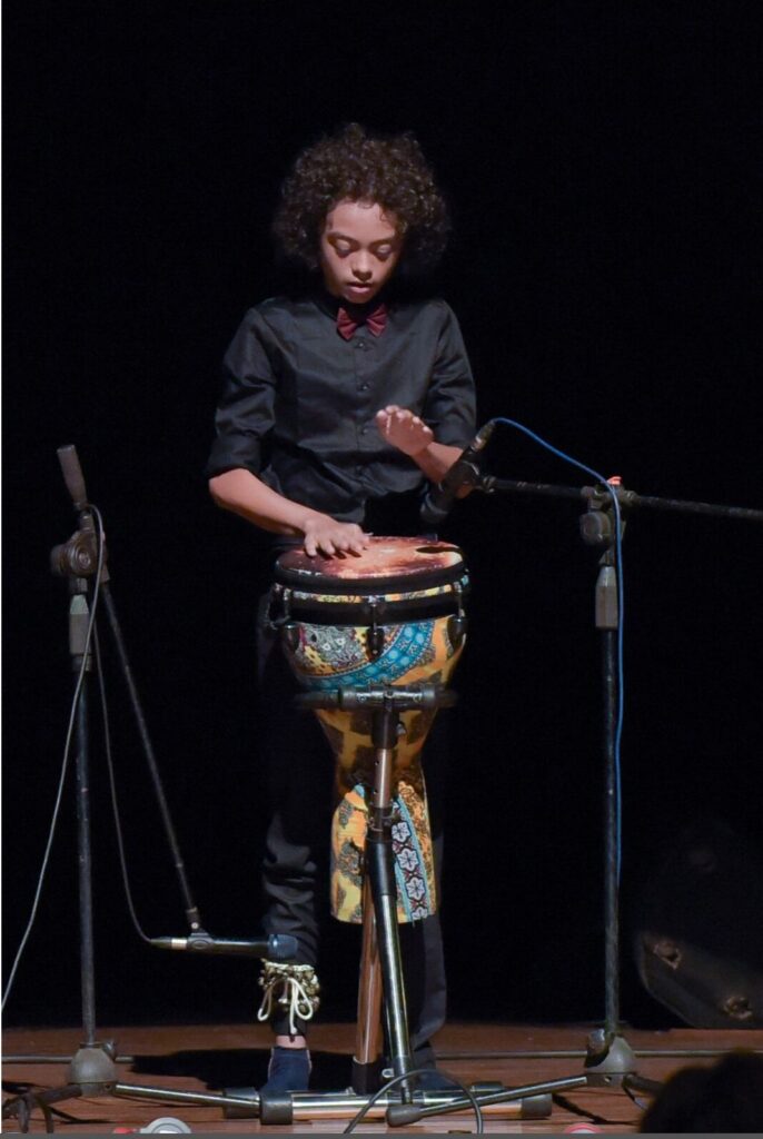 Aurum performing on the djembe, full length